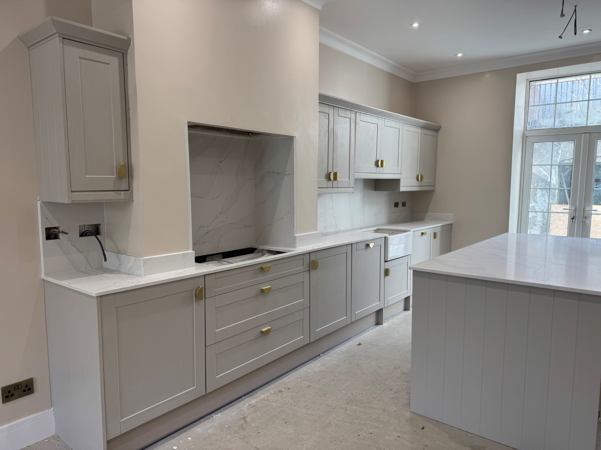 Long view through the Reno project kitchen showing cabinetry, extractor surround and island