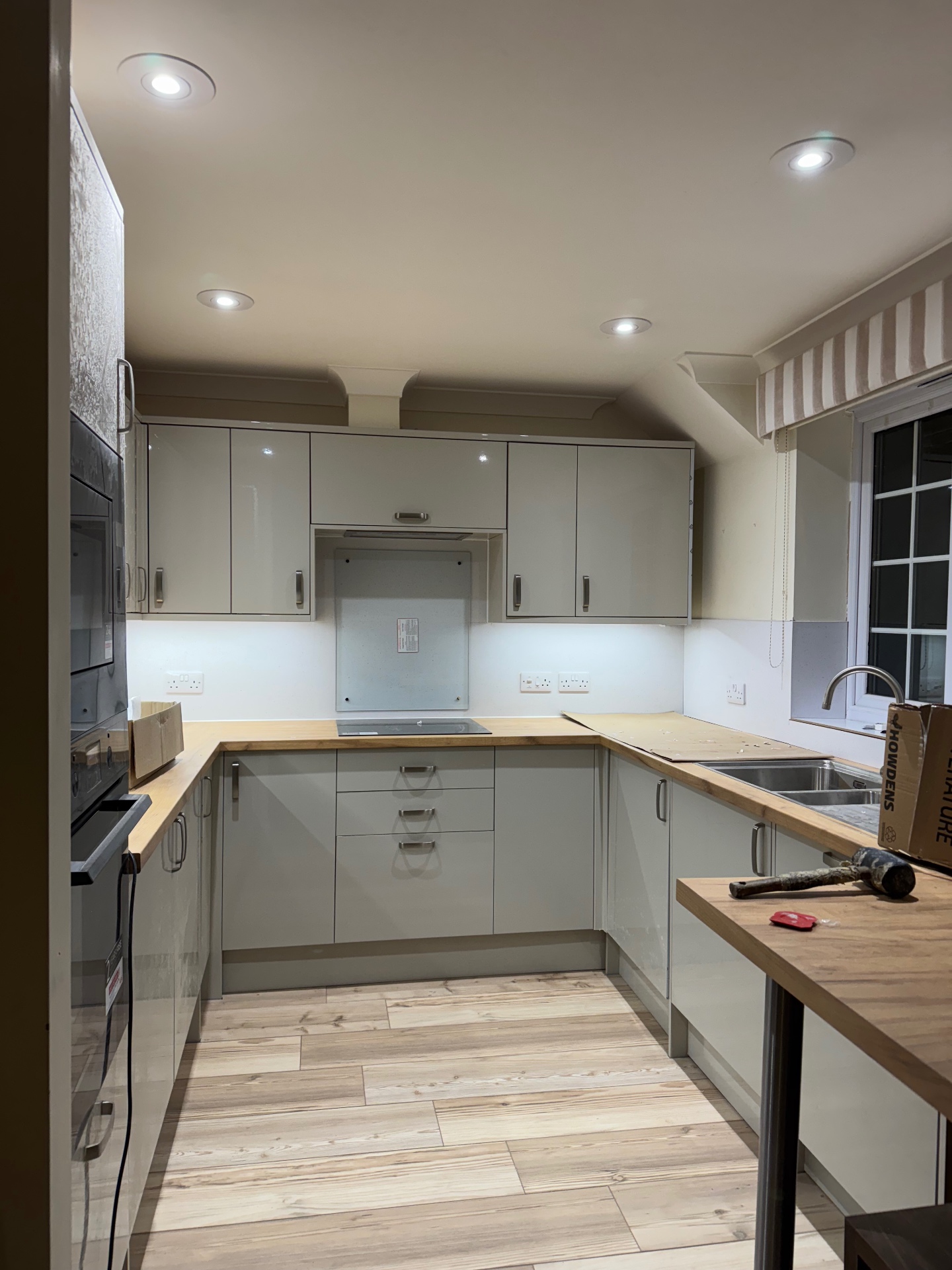 Completed Mumbles Reno kitchen from the dining side with sink, window and fitted cabinetry