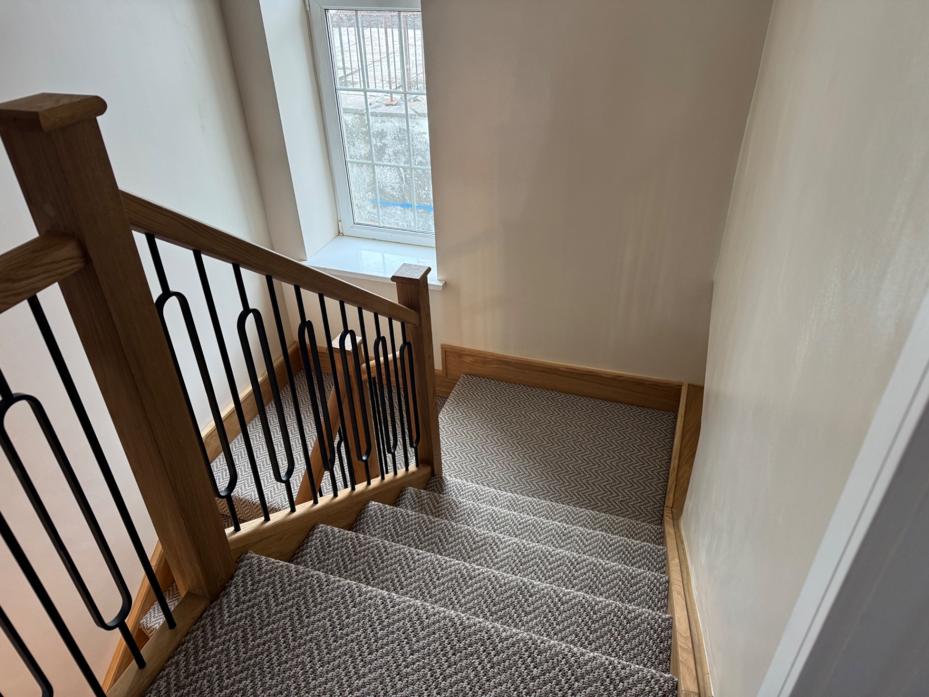 Carpeted oak staircase with detailed trim