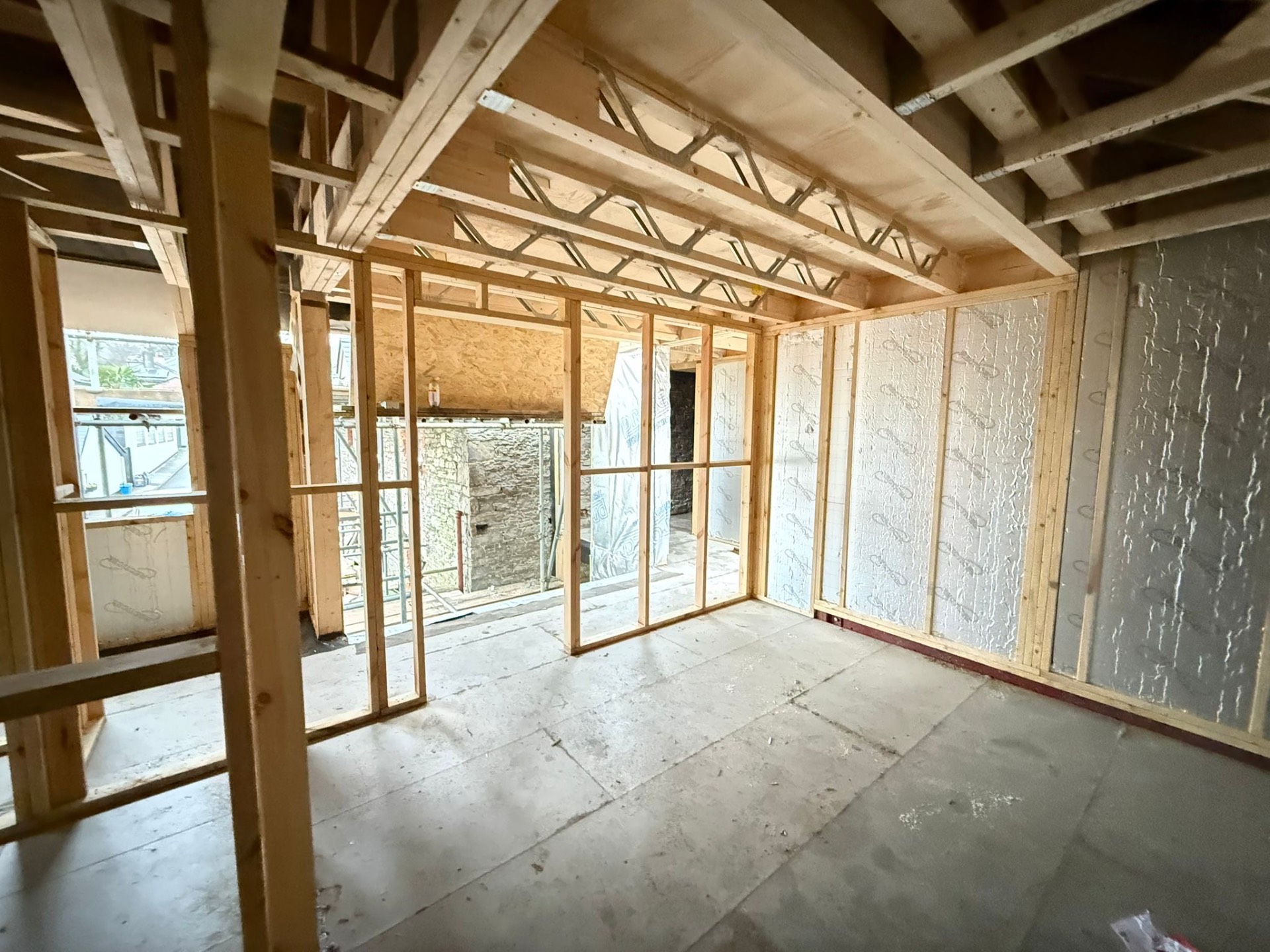 First floor room framing with engineered joists overhead on the Airbnb conversion