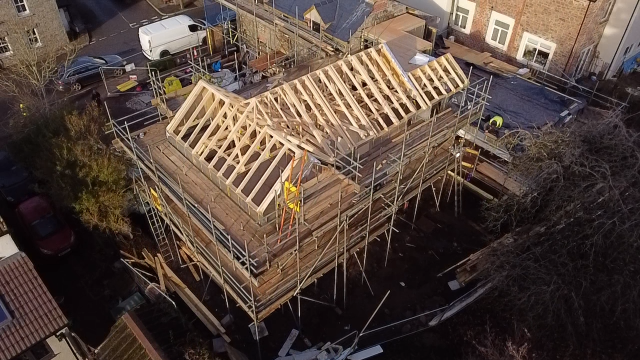 Aerial view of the hipped roof framing on the Airbnb project with scaffolding