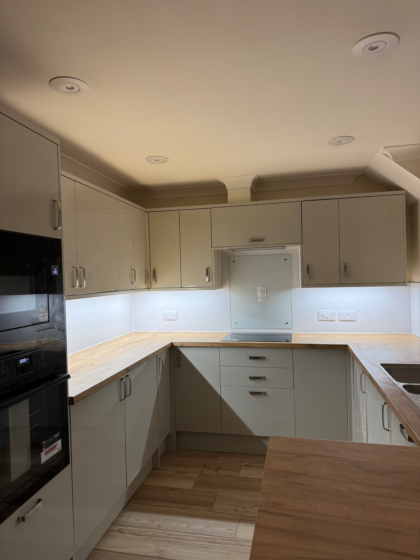 Soft-lit view of the completed Mumbles Reno kitchen highlighting the worktop runs and fitted units