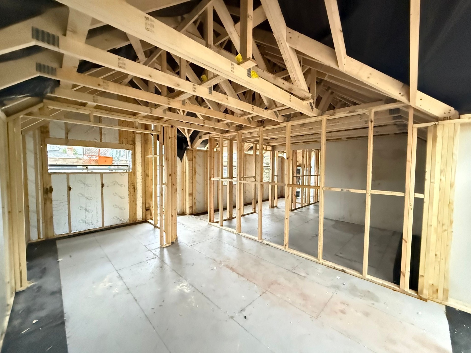 Second floor interior with attic trusses, stud partitions and insulated walls on the Airbnb project