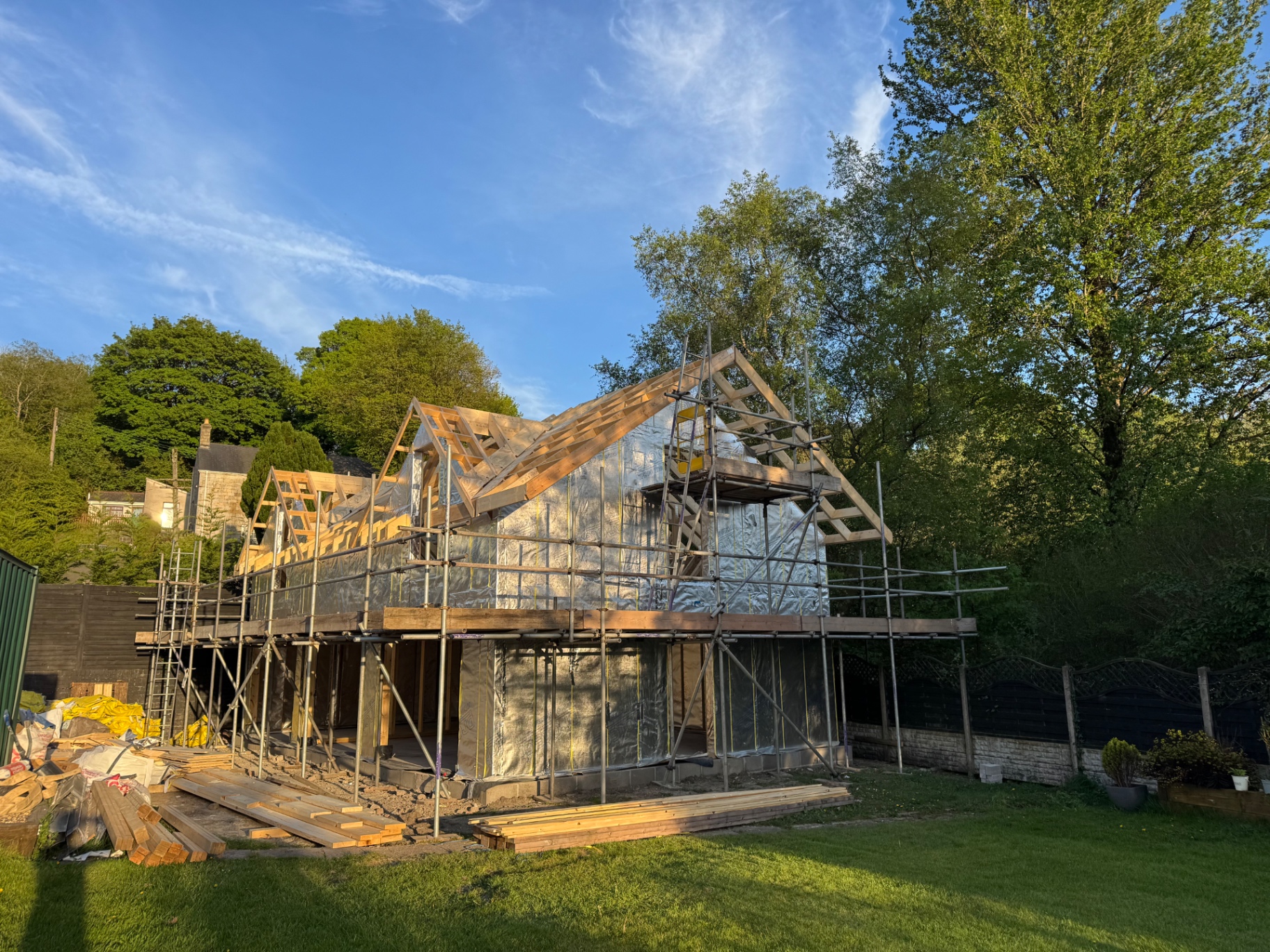 Triple garage timber frame under construction with scaffolding and roof structure in place