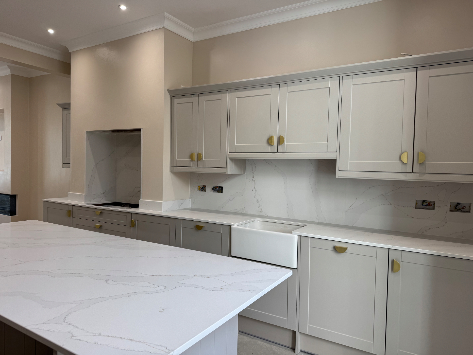 Kitchen run with shaker wall units, stone splashback and Belfast sink on the Reno project